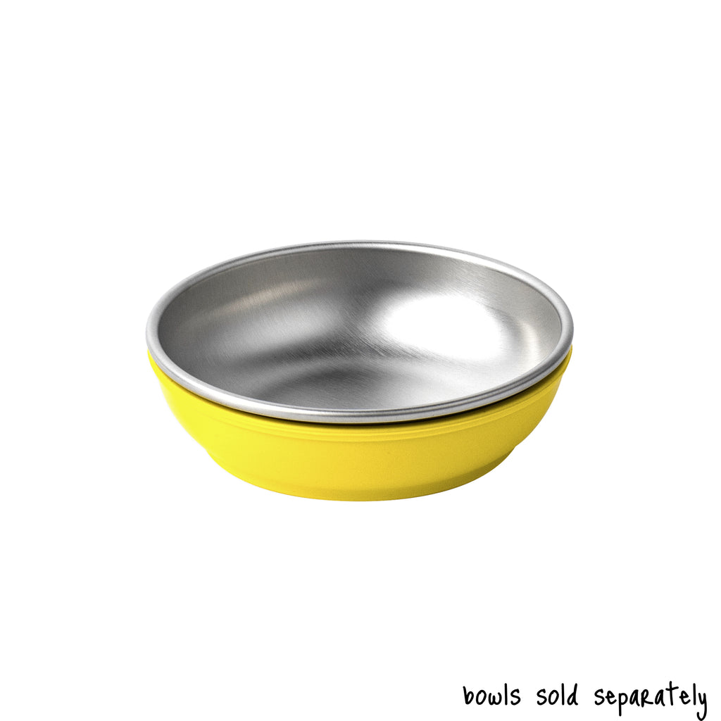 A single small size Basis Pet stainless steel dog bowl in a light yellow colored bowl cozy. Text reads "bowls sold separately".