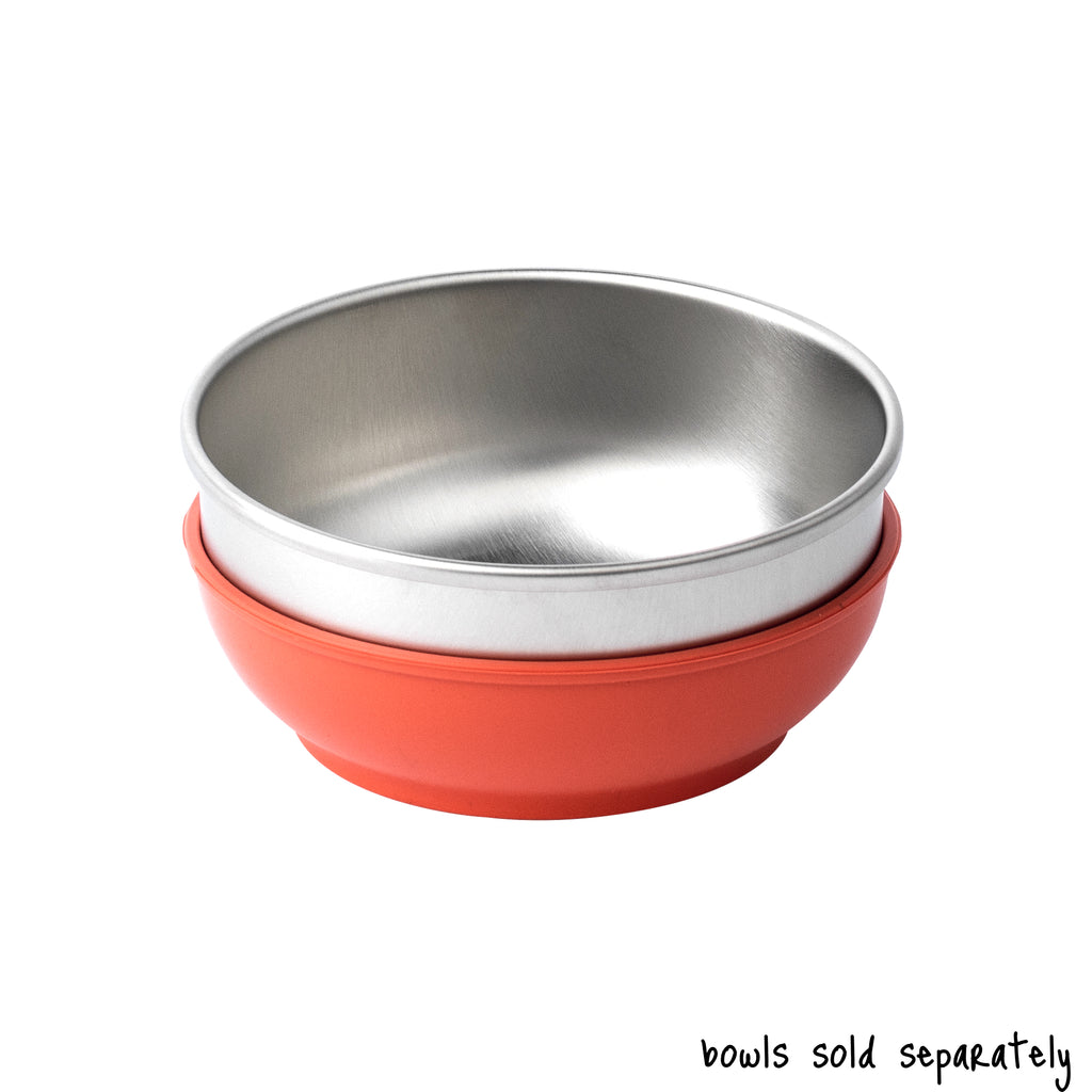 A single medium size Basis Pet stainless steel dog bowl in a coral colored bowl cozy. Text reads "bowls sold separately".
