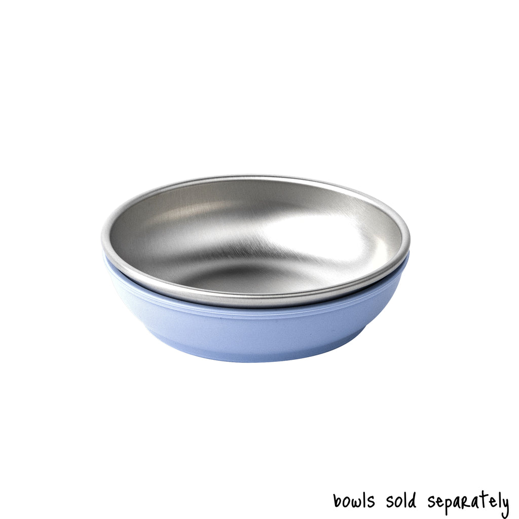 A single small size Basis Pet stainless steel dog bowl in a light blue colored bowl cozy. Text reads "bowls sold separately".