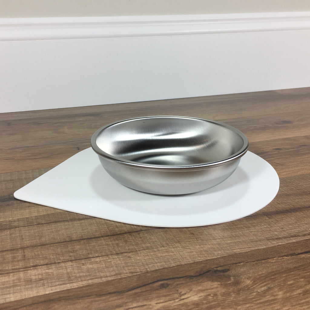 A single Basis Pet stainless steel cat bowl on a regular size Ultra Grip Mat, both on a wood floor and shown from a side angle.
